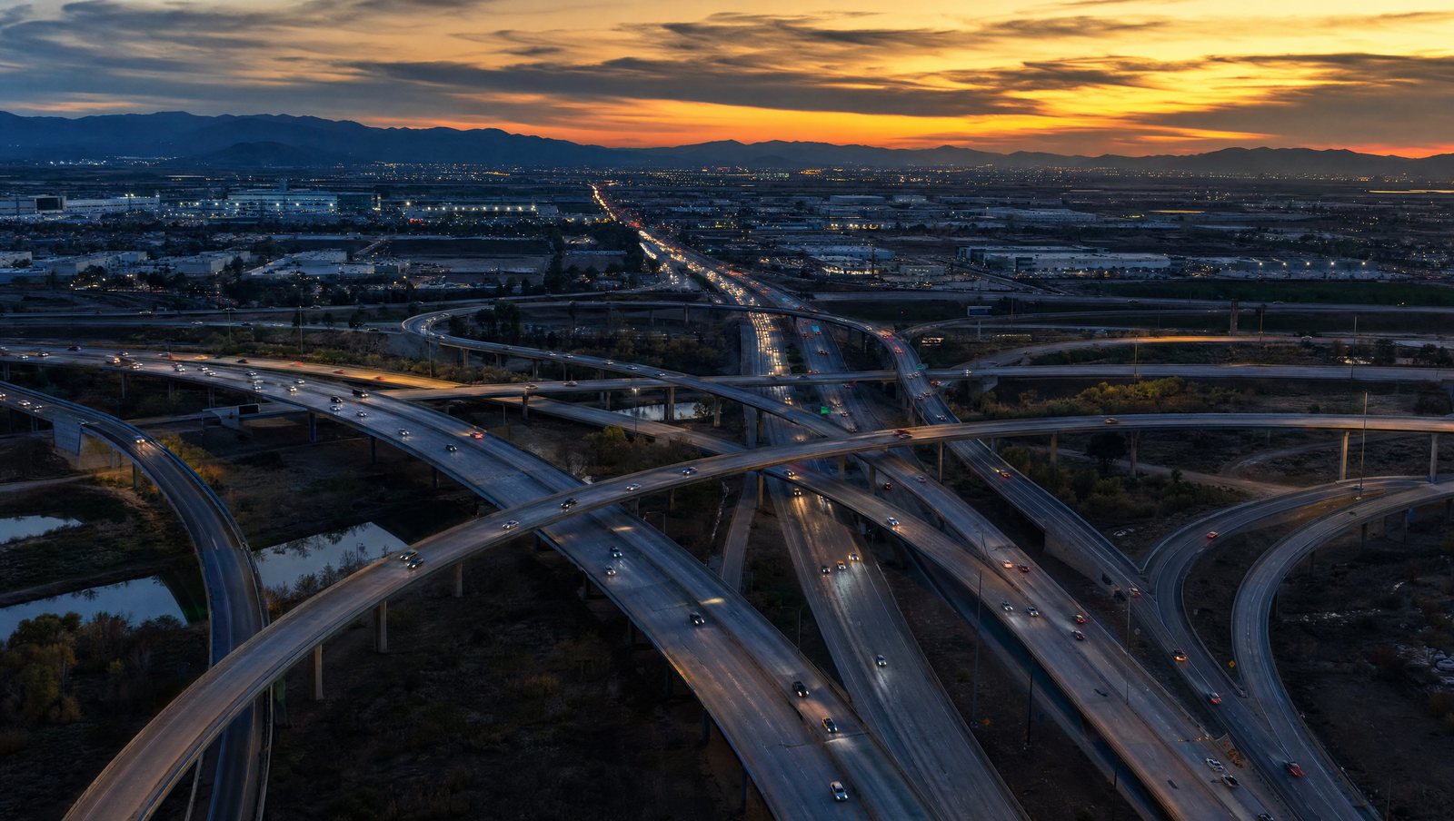Aerial view of a busy highway interchange at dusk, with ramps crossing in every direction